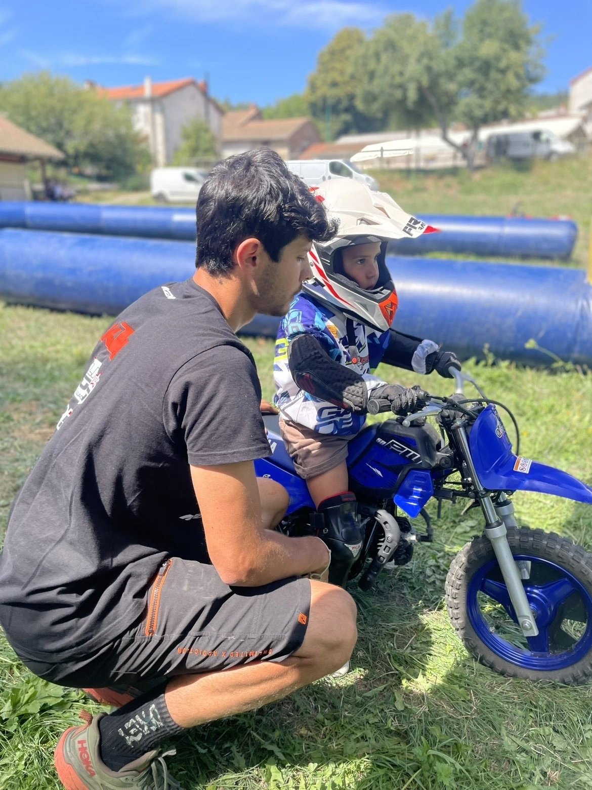 Animation moto sur circuit gonflable, enfant encadré par un éducateur